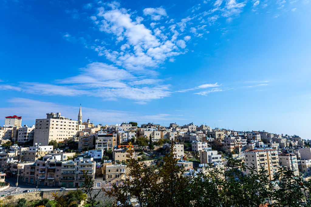 Beautiful panoramic view of Bethlehem cityscape under a vibrant blue sky, showcasing historical architecture.